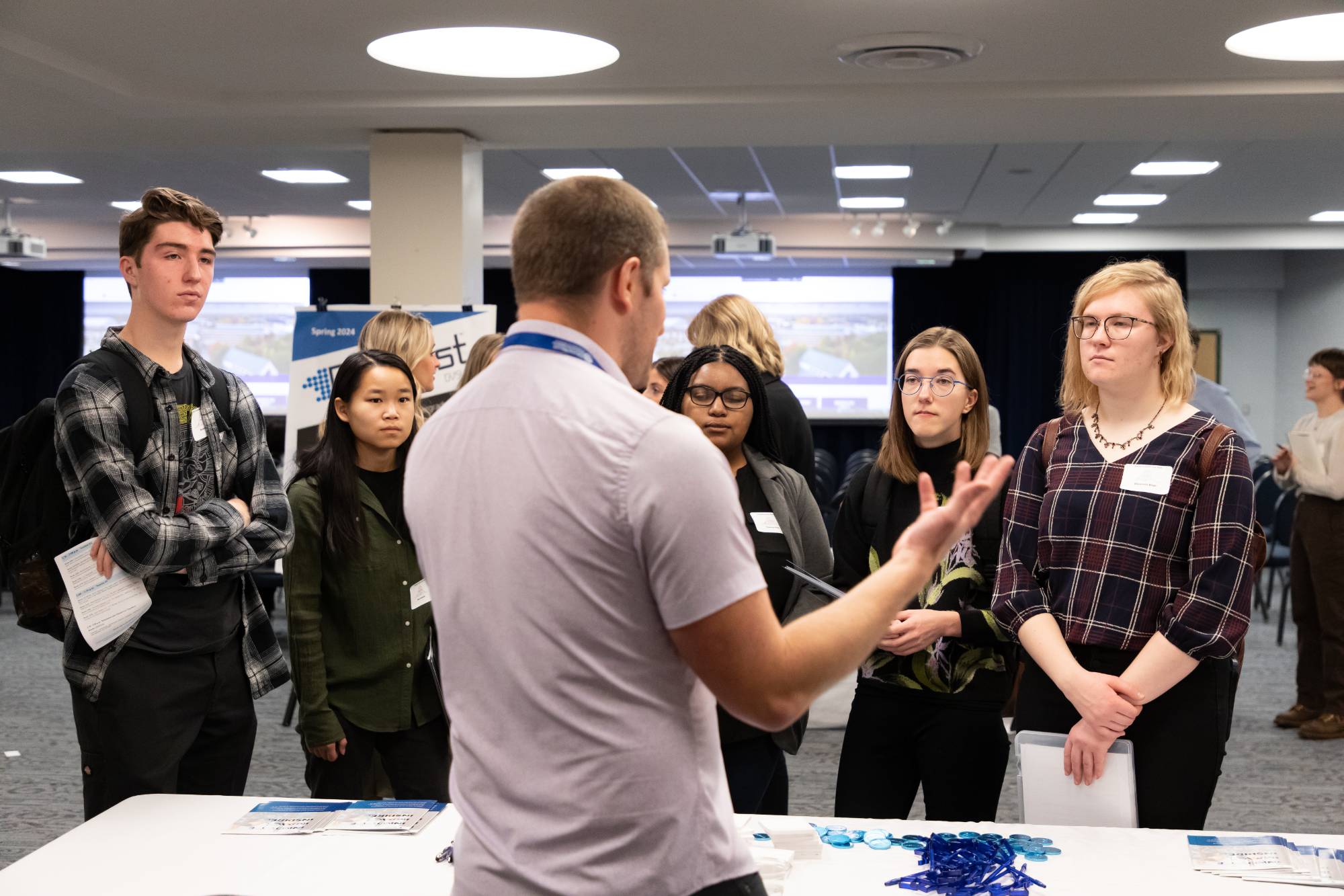 Statistics graduate students speaking with vendor at a table for Career day